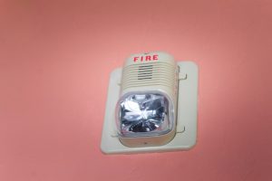 Fire alarm pada dinding bangunan berwarna merah